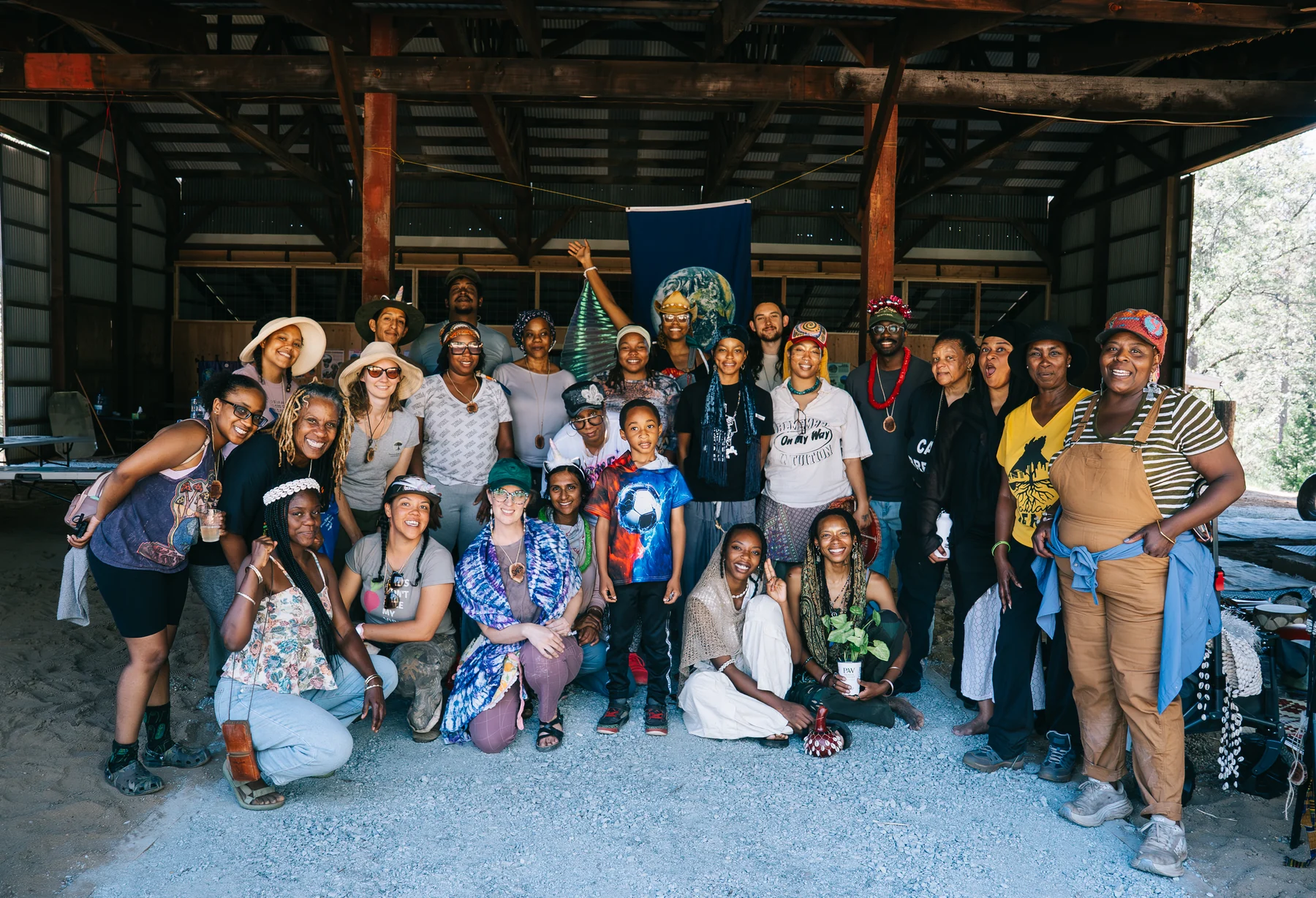 The Becoming BAES community gathers for a large group portrait inside a timber-framed space.