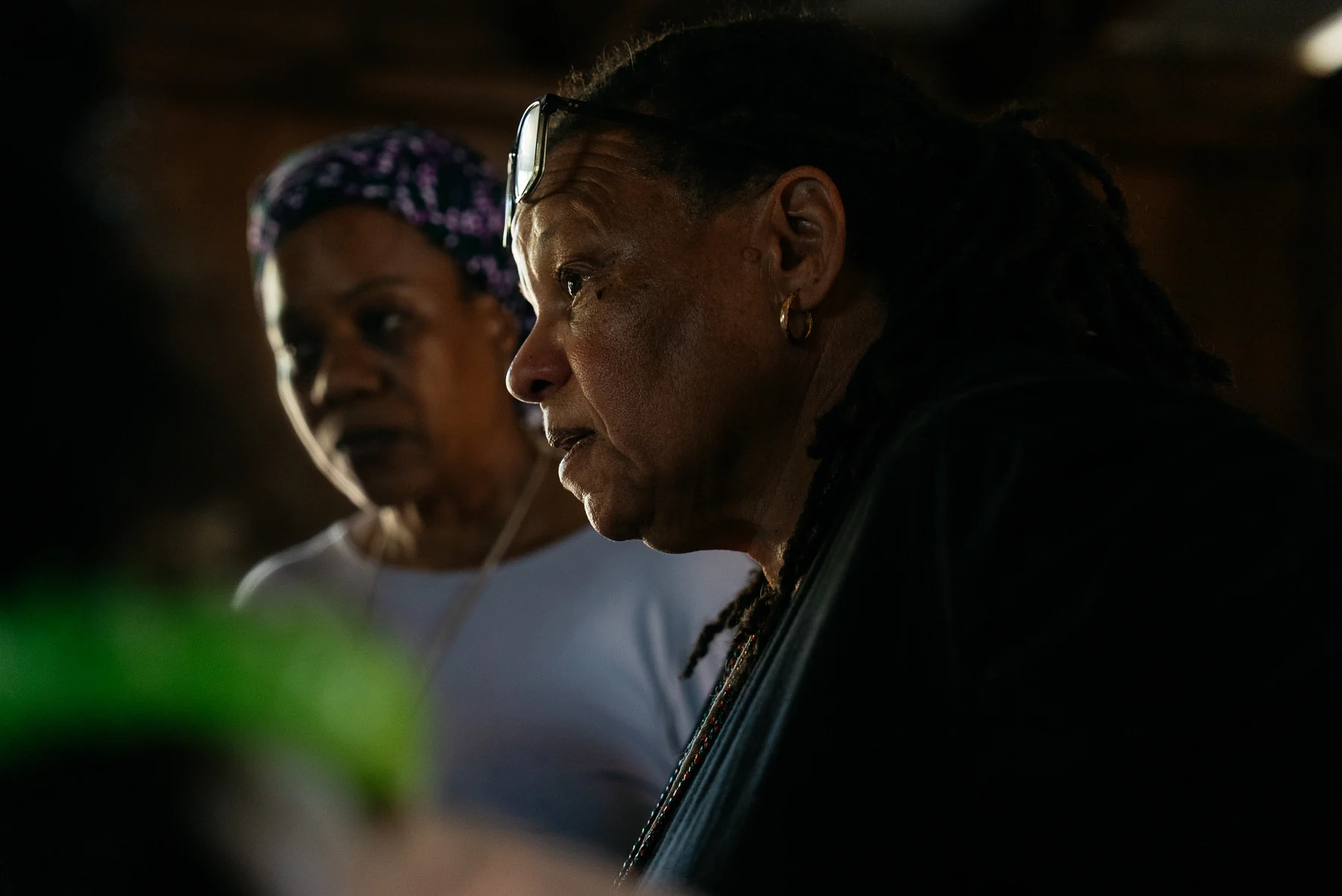 Two participants listen in a close, softly lit view inside the gathering space.