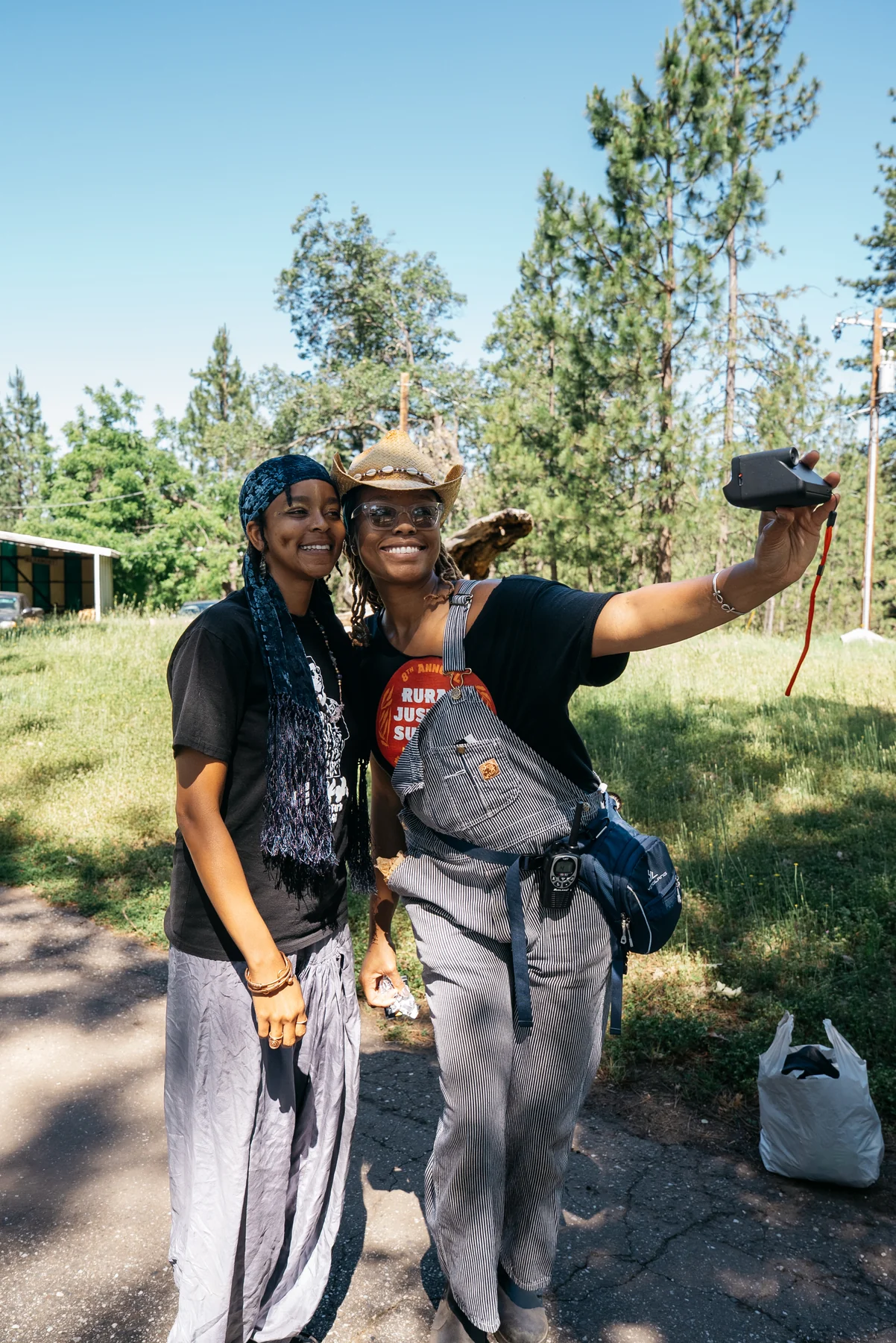 Two participants smile for a photograph taken with an instant camera outside.