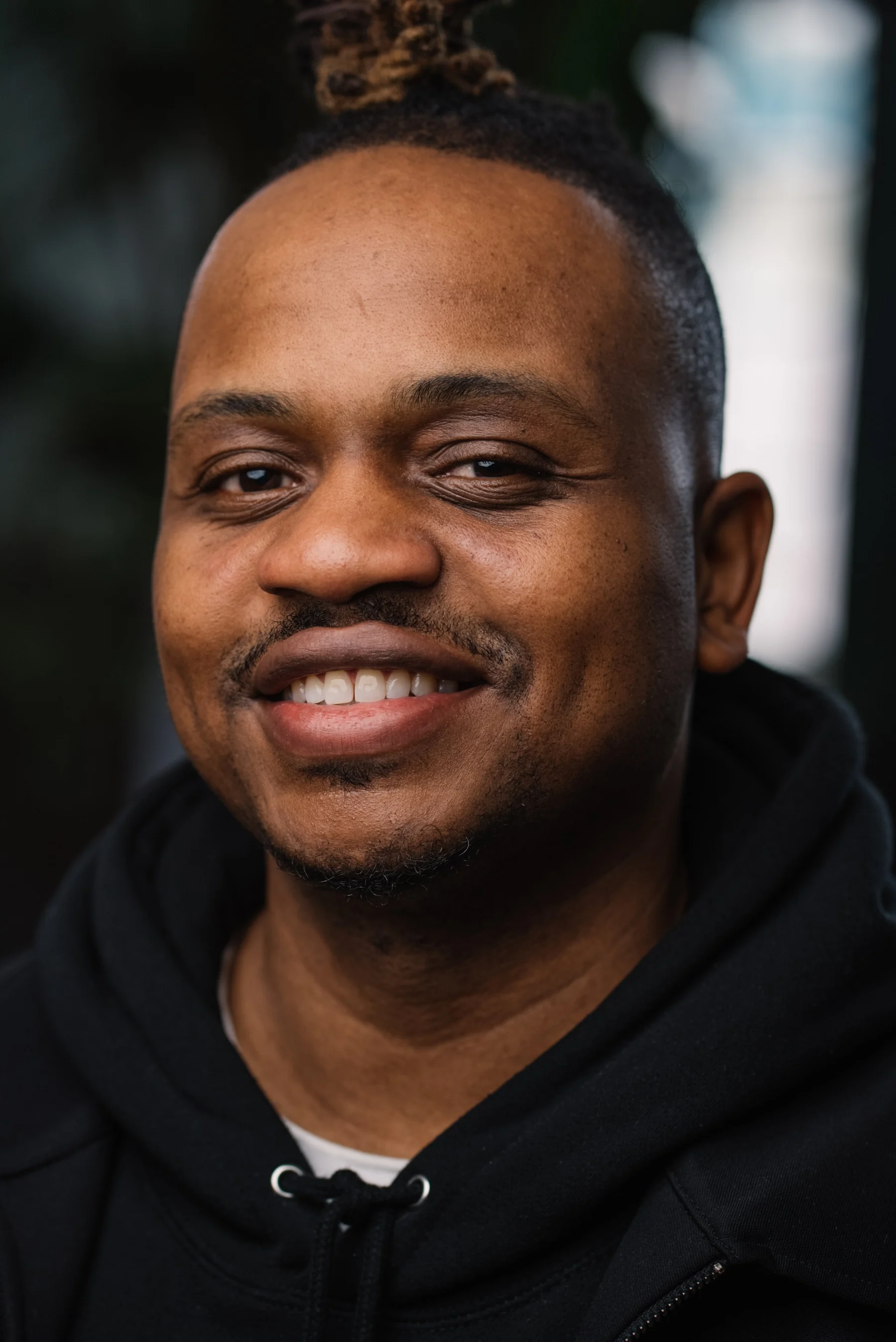 Live Free USA headshot: Smiling subject wearing a black hoodie.
