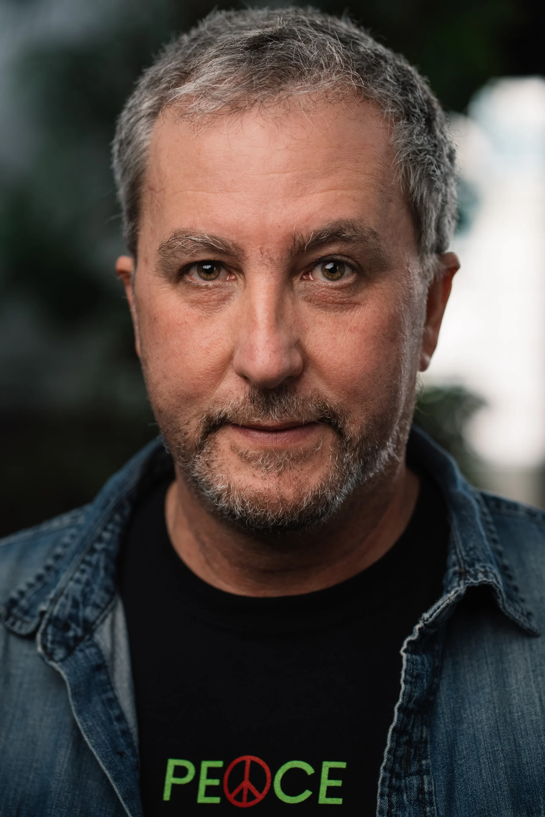 Live Free USA headshot: Subject with a salt-and-pepper beard wearing a blue overshirt.