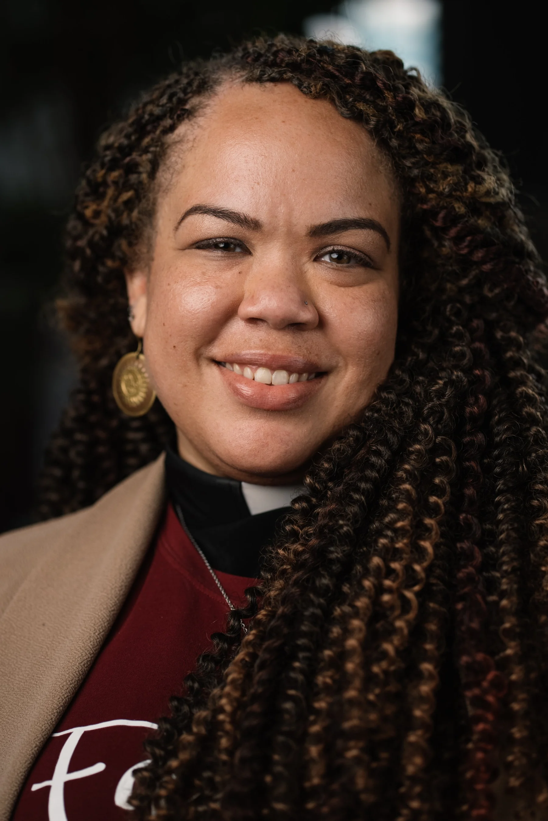 Live Free USA headshot: Subject with long braids wearing a burgundy stole.