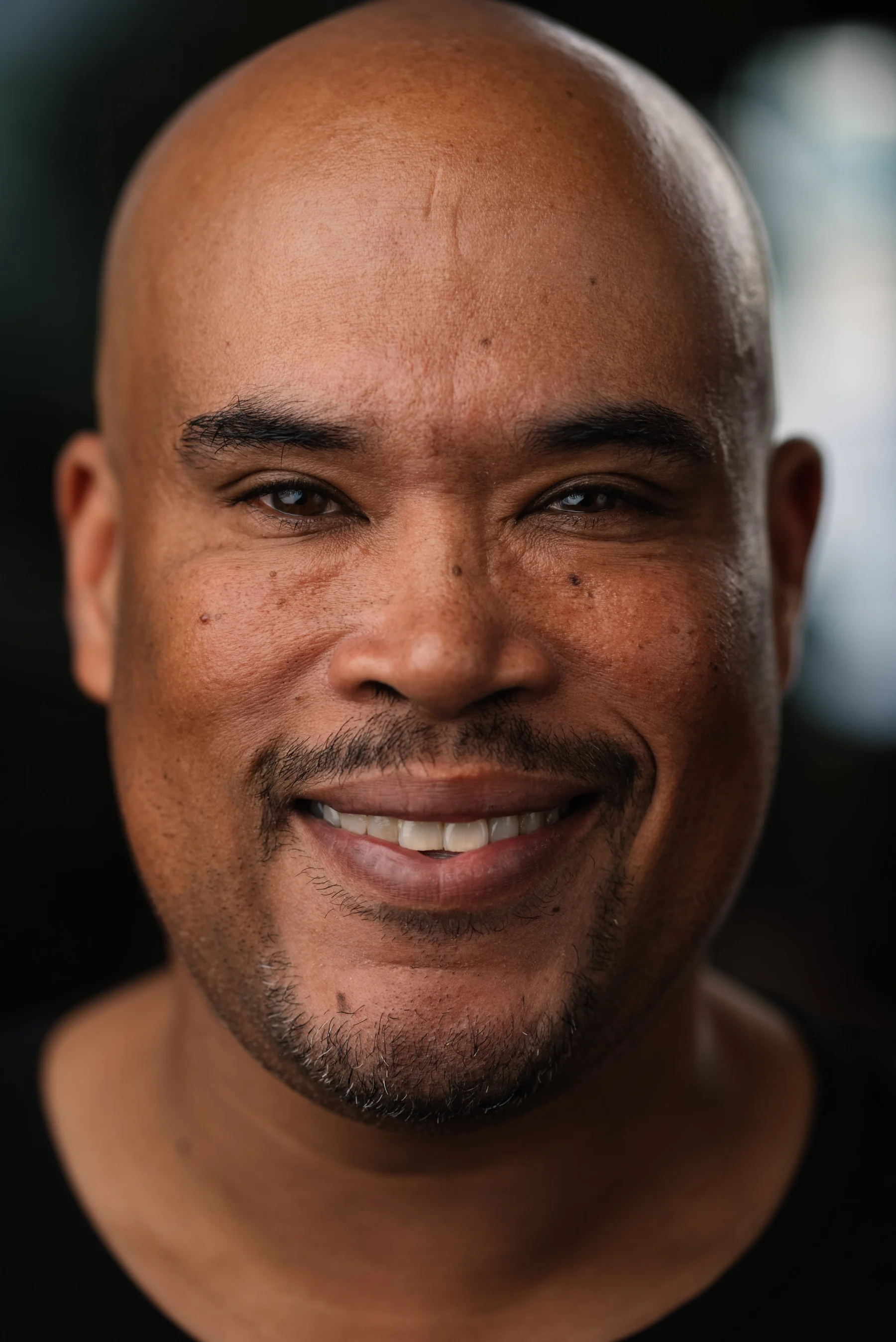 Live Free USA headshot: Smiling subject wearing a black collared shirt.