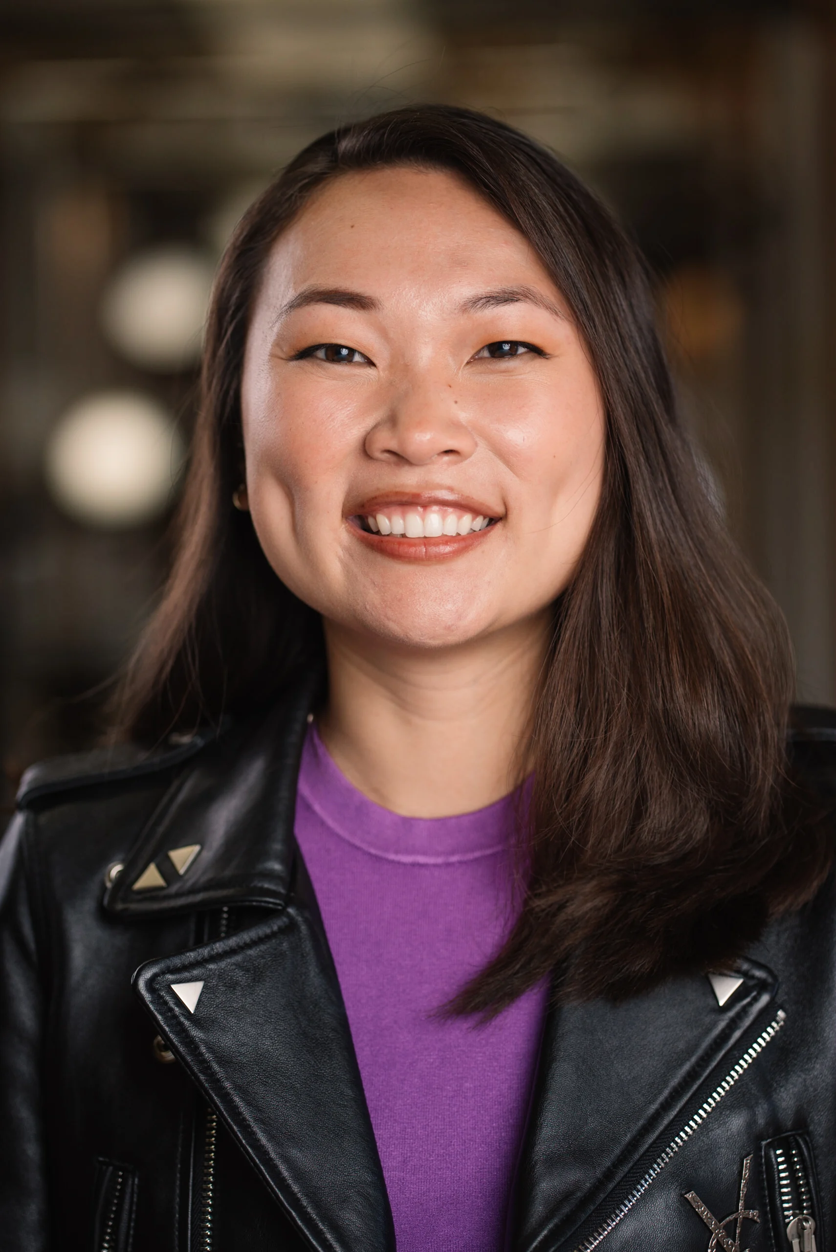 Searchlight portrait with a black leather jacket and purple shirt.