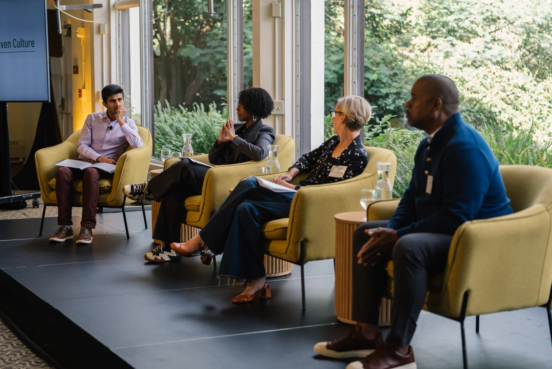 Four panelists seated in yellow armchairs during a conversation at Tipping Point Community’s Executive Summit.