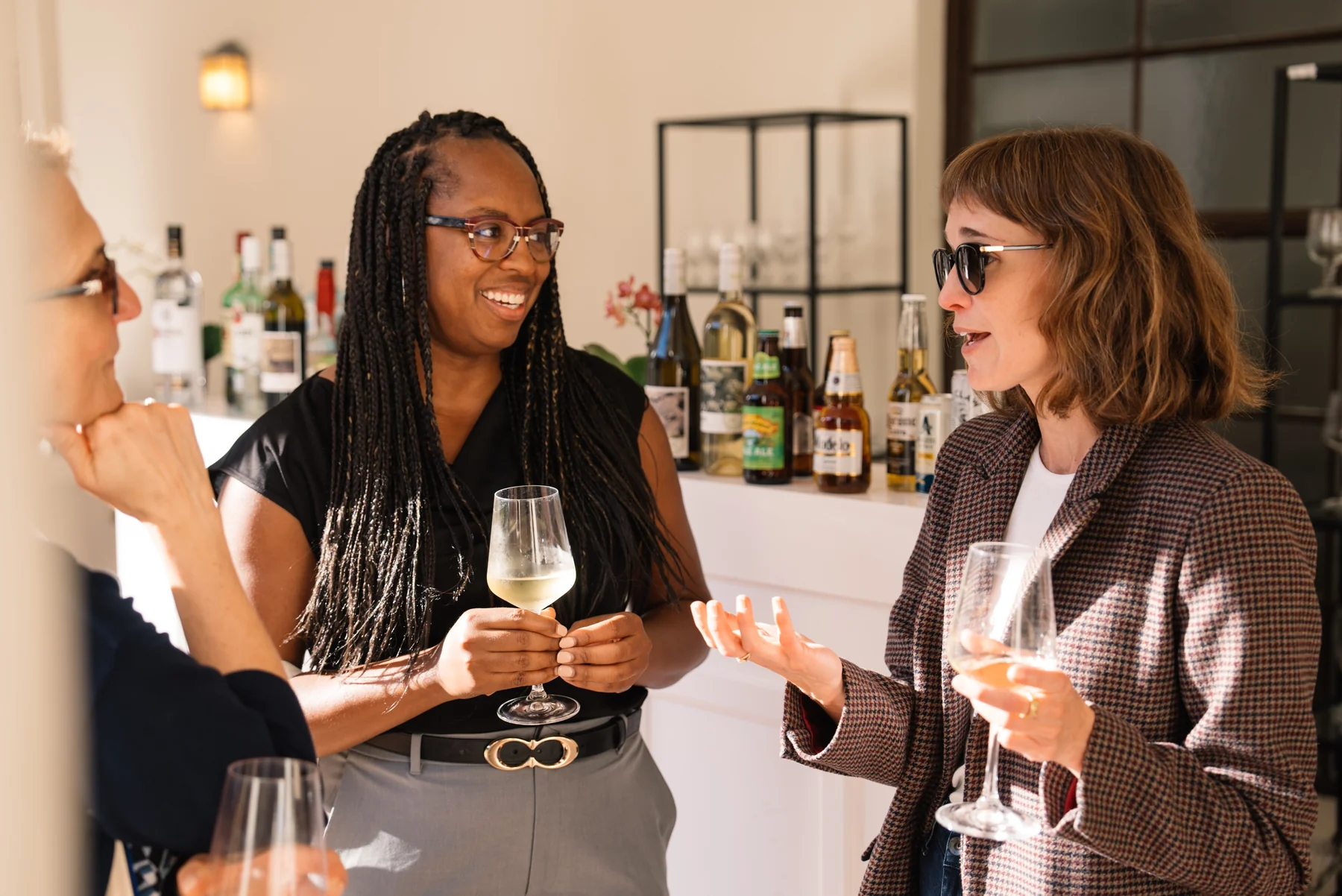 Two guests talking over drinks in warm afternoon light.